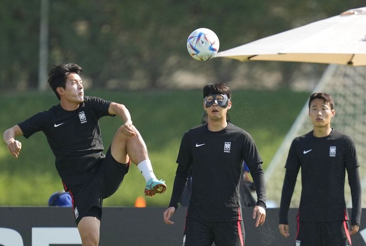 Son Heung-min (esquerda), Hong Chul e Son Jun-ho (direita) na formação em Doha, 04 Dez 2022 - Lee Jin-man/Copyright 2022 A AP. Todos os direitos reservados